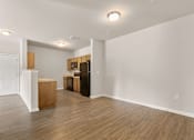 Thumbnail 3 of 16 - A kitchen area with wooden floors and white walls.