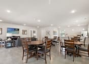 Thumbnail 7 of 16 - A dining room with a large table and chairs.