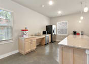 Thumbnail 8 of 16 - A kitchen with a white counter top and wooden cabinets.