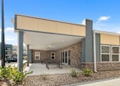 Thumbnail 10 of 16 - A modern building with a covered outdoor seating area.