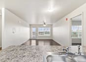 Thumbnail 11 of 32 - A spacious room with a sink and a ceiling fan.