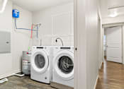 Thumbnail 17 of 32 - Two front load washing machines in a laundry room.