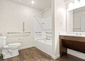 Thumbnail 18 of 32 - A white toilet is next to a white sink in a bathroom.