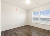 Thumbnail 19 of 32 - A room with a window and a wooden floor.