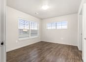 Thumbnail 20 of 32 - A room with wooden flooring and a window with blinds.