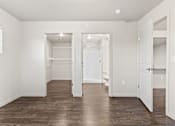 Thumbnail 21 of 32 - A large, empty room with wooden floors and white walls.