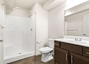 Thumbnail 22 of 32 - A white toilet sits next to a sink in a bathroom.