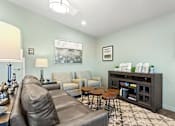 Thumbnail 4 of 32 - A living room with a grey couch and a coffee table.