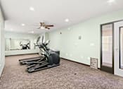 Thumbnail 5 of 32 - A room with a row of treadmills and a fan on the ceiling.