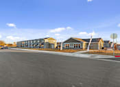 Thumbnail 7 of 32 - A parking lot with a building in the background.