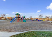 Thumbnail 8 of 32 - A playground with a green and blue slide and a red swing set.