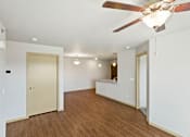 Thumbnail 23 of 27 - A room with a ceiling fan and wooden floors.