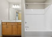 Thumbnail 7 of 27 - A white bathroom with a sink and a bathtub.