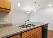 Thumbnail 13 of 27 - A kitchen with a sink and a dishwasher.
