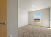 Thumbnail 26 of 27 - A room with a carpeted floor and a picture hanging on the wall.