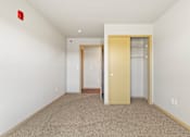 Thumbnail 9 of 27 - A room with two doors and a carpeted floor.