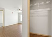Thumbnail 10 of 27 - A white room with a wooden floor and a white wall with a door on the right.