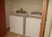 Thumbnail 8 of 18 - Two white washing machines in a small room.