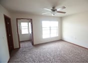 Thumbnail 5 of 15 - A room with a ceiling fan and two windows.