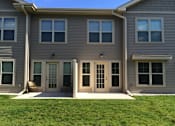 Thumbnail 11 of 15 - A grey house with a white door and windows.