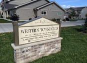 Thumbnail 1 of 15 - A sign for Western Townhomes in front of some houses.