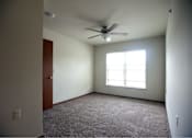 Thumbnail 9 of 15 - A room with a ceiling fan and a window.