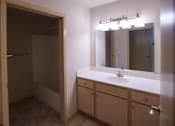 Thumbnail 17 of 25 - A bathroom with a sink, mirror, and cabinet.