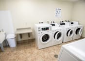 Thumbnail 14 of 25 - A laundry room with a white dryer and washer.