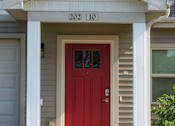 Thumbnail 3 of 25 - A house with a red door and the number 20210 on the wall above it.