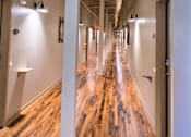 Thumbnail 5 of 33 - A long hallway with wood floors and white walls.
