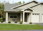 Thumbnail 10 of 21 - A house with a garage door and a window.