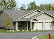 Thumbnail 15 of 21 - A house with a grey roof and a red fire hydrant in front of it.
