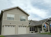 Thumbnail 17 of 21 - A house with a grey facade and a brown roof.