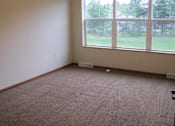 Thumbnail 13 of 18 - A room with a carpeted floor and a large window.