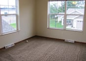 Thumbnail 14 of 18 - A room with a carpeted floor and two windows.
