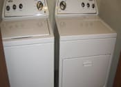 Thumbnail 18 of 18 - Two white washing machines in a small room.