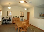 Thumbnail 7 of 18 - A dining room with a wooden table and chairs.