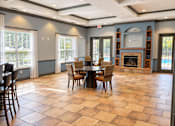 Thumbnail 8 of 14 - A large dining room with a fireplace and a checkered floor.
