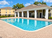 Thumbnail 5 of 14 - A pool with a building in the background.