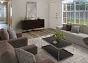 Thumbnail 21 of 21 - A living room with a brown sofa, a grey armchair, a black coffee table, and a white door.
