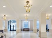 Thumbnail 5 of 5 - A large, well-lit lobby with a marble floor and a chandelier hanging from the ceiling.
