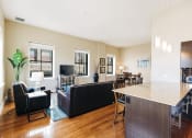 Thumbnail 3 of 39 - a living room with couches and a kitchen with a bar and a table at Metro67, TN, 38103
