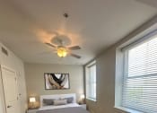 Thumbnail 8 of 39 - a bedroom with a bed and a ceiling fan at Metro67, Memphis, Tennessee, 38103