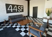 Thumbnail 8 of 12 - A black and white checkered floor in a room with a sofa and a coffee table.