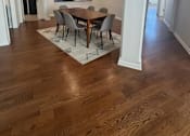 Thumbnail 10 of 12 - A dining room with a wooden table and chairs.