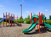 Thumbnail 15 of 18 - A playground with a red and green slide.