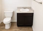 Thumbnail 8 of 9 - A white toilet sits next to a sink in a bathroom.