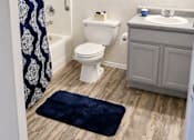 Thumbnail 4 of 9 - A bathroom with a toilet, sink, and shower curtain.