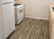 Thumbnail 6 of 9 - A kitchen with a white refrigerator and a white stove top oven.