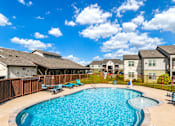 Thumbnail 16 of 46 - A swimming pool surrounded by a wooden fence and chairs.